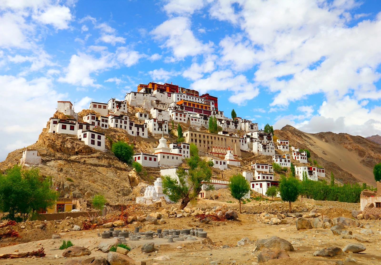 Thiksey monastery, white buildings stacked up a rocky hill under a blue sky, near Leh